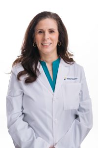 Dr. Nicole Alu in white lab coat