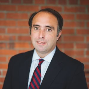 Headshot of an adult male in a suit and tie