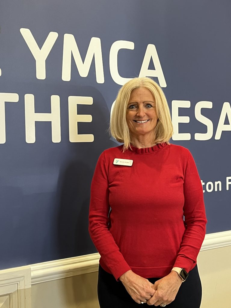 Female standing against YMCA sign
