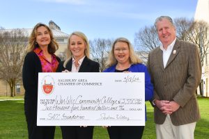 Four people holding a large check from the Salisbury Chamber of Commerce