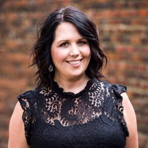 Headshot of a young women against a brick wall