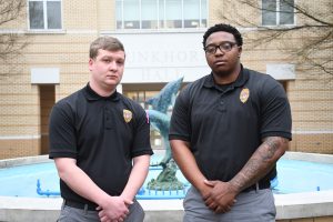 Two grown men standing beside a fountain