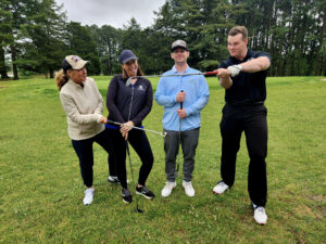Group of 4 people holding golf clubs
