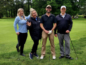Group of 2 men and 2 women holding golf clubs on a golf course
