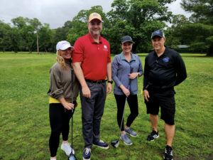 Group of 4 golfers posing on the golf course