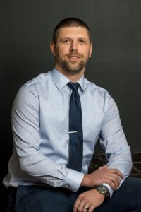 Headshot of a young man in business attire