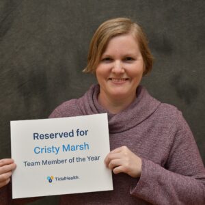 female holding a sign with her name on it