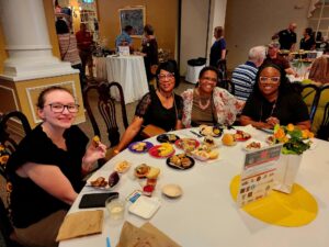 Smiling group of people sitting at a table at the Taste of the Town event