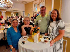 Smiling group of people sitting at a table at the Taste of the Town event