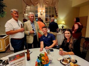 Smiling group of people sitting at a table at the Taste of the Town event