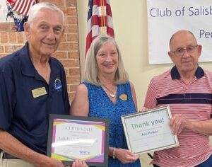 three people holding framed awards