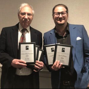 Two men holding awards