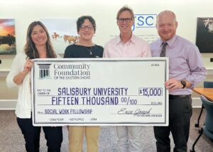 4 people holding a large check