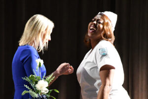 Chelsea Milligan, instructor of nursing at Wor-Wic Community College, bestows a nursing pin on graduate Angelique Bonner.