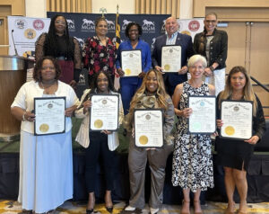 Large group of people holding awards at an event