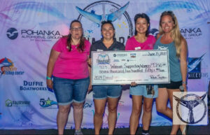 Four girls holding a large check