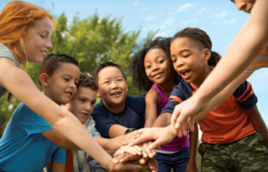 group of kids putting their hands together