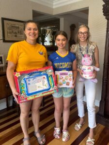 three young girls holding toys