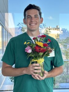 Male nurse holding flowers