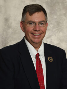 Headshot of a man in suit and tie