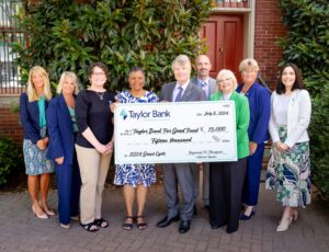 Group of people from Taylor Bank holding a large check