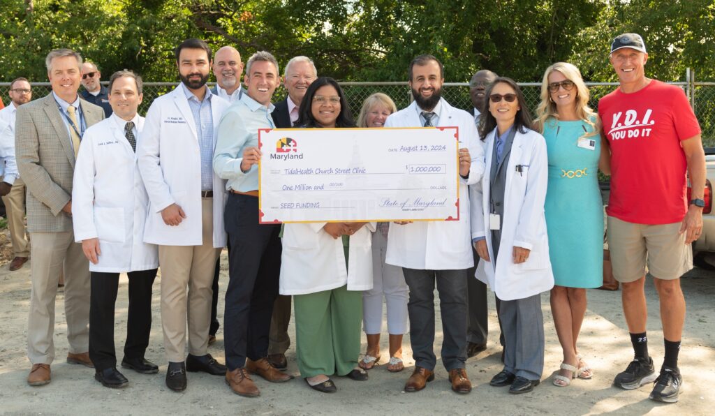 Group of doctors holding a large check