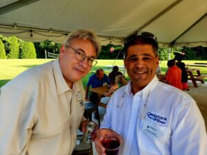 Man in a glasses next to a man holding a drink