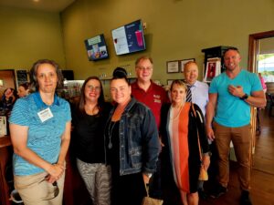 Group of smiling people indoors at the chamber mixer