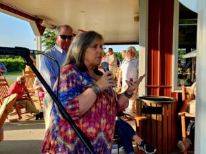 Woman in a colorful shirt talking on a microphone