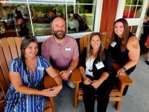 Group of smiling people outside in patio chairs