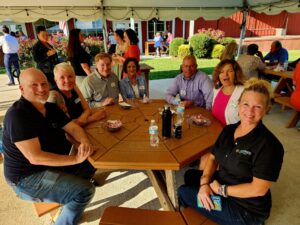 Group of smiling people sitting around a picnic table