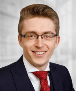 Headshot of a young man in a suit and tie