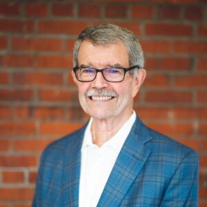 Headshot of Henry Hanna against a brick wall