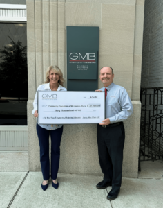 two people holding a large check