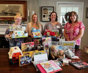 group of girls standing around a table full of toys