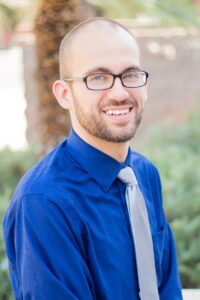 Headshot of SU Employee in a collar shirt and tie