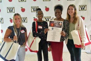 four teachers holding brand new tote bags