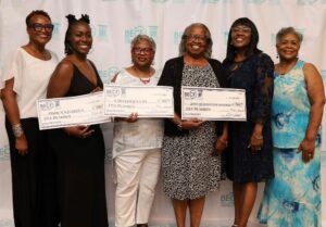 group of women holding large checks