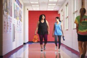 Adult and child walk down hall together