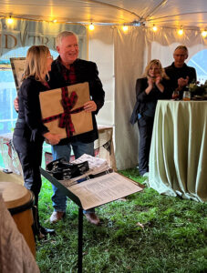 Two people holding a wrapped gift with a bow