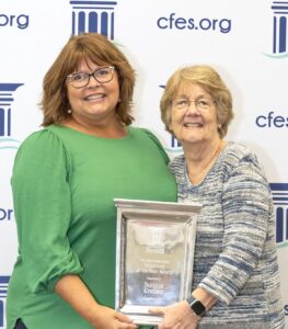 two ladies holding plaque