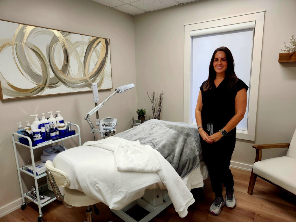 Aesthetician standing next to a wellness table