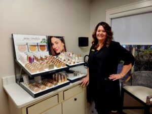 Aesthetician standing infront of a display of products