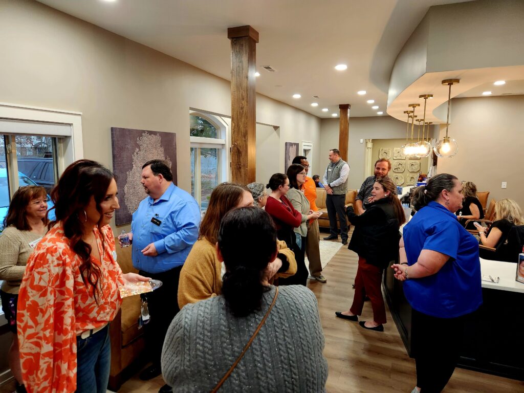 Group of people mingling at a ribbon cutting event