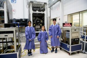 students in front of space equipment