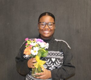 Shaymija Dowdell Holding Flowers as Award Recipient