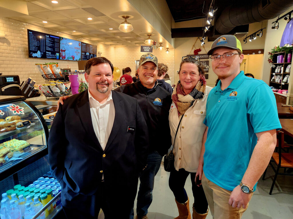 Group of ribbon cutting attendees inside PJs Coffee