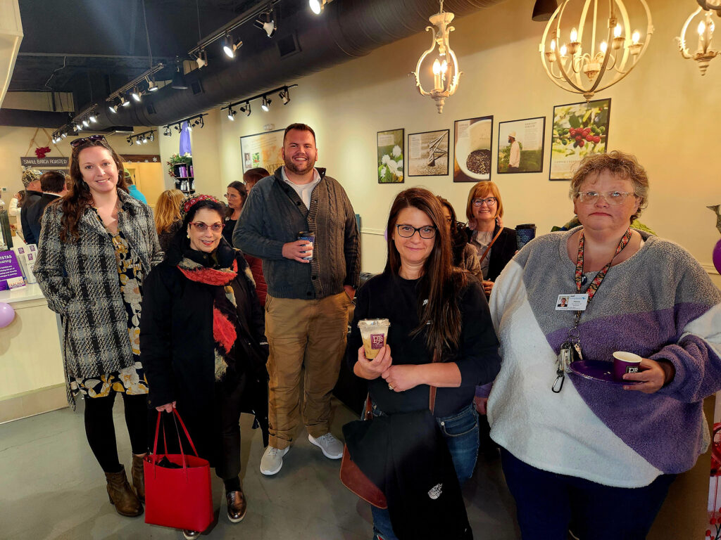 Group of ribbon cutting attendees inside PJs Coffee