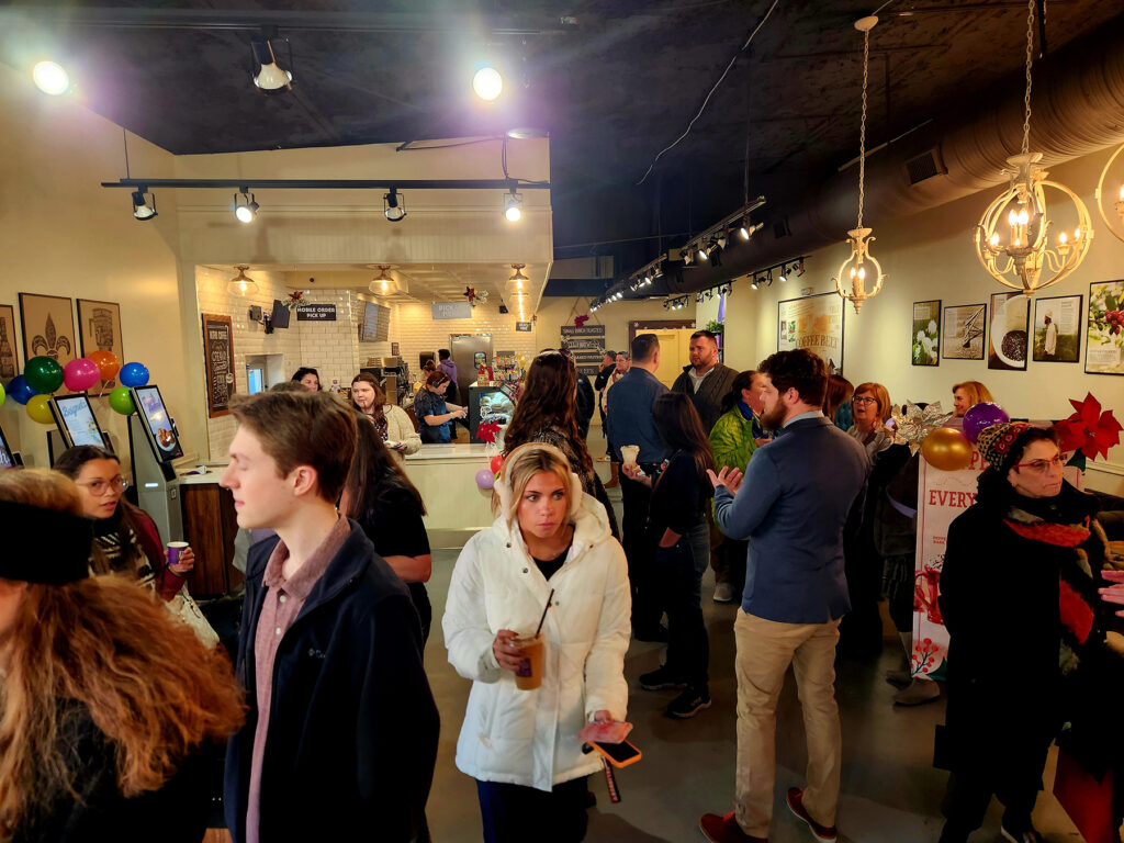 Group of ribbon cutting attendees inside PJs Coffee