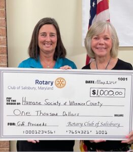 A Round for Community Golfing Two women standing with a check
